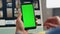 Freelancer finger scrolling greenscreen smartphone closeup. Man mockup cellphone