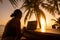 Freelancer girl with a computer among tropical palm trees work on the island in sunset