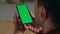 Freelancer hands holding greenscreen smartphone at home closeup. Man reading