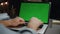 Freelancer hands texting greenscreen laptop dark room closeup. Man arms typing
