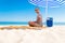 Freelancer, happy successful businessman in sunglasses on vocation with laptop on the beach under umbrella