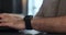 Freelancer man using smart watches. Browsing notifications and message. Smartwatch touching screen.