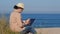 Freelancer woman working in her notebook on beach