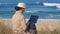 Freelancer woman working in her notebook on beautiful coastline