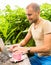 Freelancer working in park. Man sitting at rough country wooden