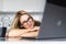 Freelancer yawns. Young sleepy woman sitting in the kitchen at home looks tired and yawning while working at a laptop. Business in