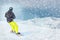 Freeride snowboarder rolls on a snow-covered slope leaving behind a snow powder. space for text