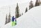 Freerider man is standing on the mountainside in a helmet and wi