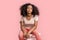 Freestyle. African girl sitting on chair isolated on pink posing confident