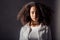 Freestyle. African girl in white outfit standing isolated on gray looking camera cool close-up in the dark