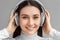 Freestyle. Woman in headset standing isolated on gray listening song smiling cheerful close-up