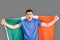 Freestyle. Young man standing  on grey with irish flag supporting team motivated