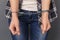 Freestyle. Young woman in cuffs standing studio isolated on grey hands close-up