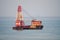 Freetown, Sierra Leone - January 09, 2014: Old and rusting red and white construction ship in bay of Freetown