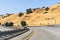 Freeway crossing the golden hills of Alameda County on a hot summer day; East San Francisco Bay Area, California