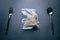 freeze cooked spaghetti or noodles in vacuum pack with spoon and fork on grunge table