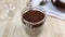 Freeze dried coffee is poured into glass jar, granules form hill. Making caffeine drink. Close-up, wooden table