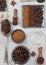 Freeze dried instant coffee granules with ground coffee and beans in steel plate with glass jar and various spoons and scoops on