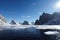 freezing fiord, with view of towering cliffs, and distant peaks visible in the background