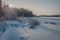 Freezing lake covered with snow at sunset. Footprints on a snow covered lake.