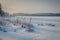 Freezing lake covered with snow at sunset. Footprints on a snow covered lake.