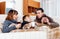 Freezing parents and teenage son warming near warm heater