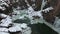 Freezing river at the bottom of the gorge with icicles on the rocks