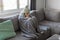 Freezing Woman Covered With Warm Blanket Sitting On Couch In Living Room