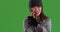 Freezing woman talking on cellphone while staying warm on green screen