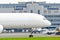 Freight cargo airplane in the parking lot of the airport, against the background of the cargo terminal of the aerodrome building