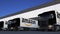 Freight semi trucks with Amazon.com logo loading or unloading at warehouse dock. Editorial 3D rendering