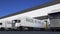 Freight semi trucks with MADE IN THE UK caption on the trailer loading or unloading. Road cargo transportation 3D