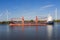 Freight ship on a river between two wind turbines