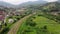 Freight train carries an electric locomotive by railway in the forest Carpathians Mountains. Aerial Photography drone