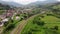 Freight train carries an electric locomotive by railway in the forest Carpathians Mountains. Aerial Photography drone wide view at
