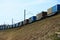 Freight train cars travel by rail on a slope