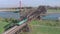 Freight Train Crossing an Iron Bridge Spanning a River