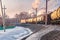 Freight train leaving a bend, trees behind an industrial area, winter evening