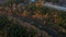 Freight train moving through autumn forest. Aerial following shot