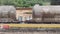 Freight train pulled by a Renfe company locomotive passes in front of the station building