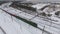 Freight train on the railway in winter. Gasoline, fuel tanks. Aerial shot.