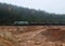 Freight train transports sand with freight wagons in a sand pit in cloudy foggy weather