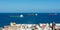 Freighter in the sea with roofs of a city in the foreground