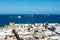 Freighter in the sea with roofs of a city in the foreground