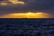 Freighter ship in the distance above the sea horizon on a sunset with dramatic sky. Gran Canaria. Spain Europe