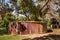 Fremantle, Australia - November 25. 2009: Large covered, old rusty metal water cistern set under green tree foiiage at Peel Winery