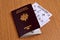 French biometric passport with a plane ticket in it on a wooden table