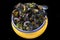 French blue mussel with herbs in a yellow. Seafood in black background