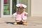 French Bulldog dog dressed up with pink nurse costume with fake arms