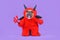 French Bulldog dog with red devil Halloween costume wearing a fluffy full body suit with fake arms holding pitchfork